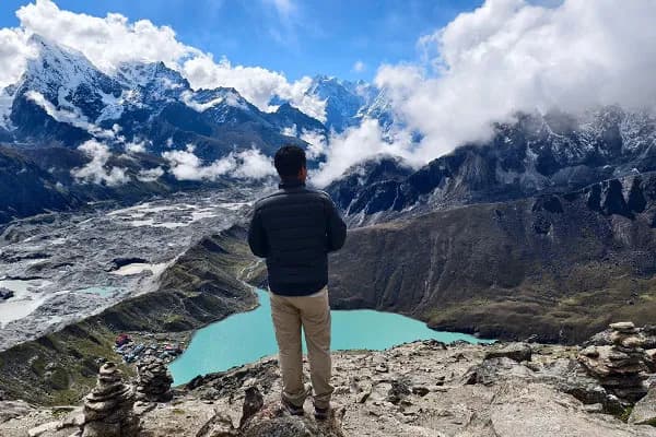 Trekker standing at Gokyo Ri viewpoint admiring the Everest region landscape