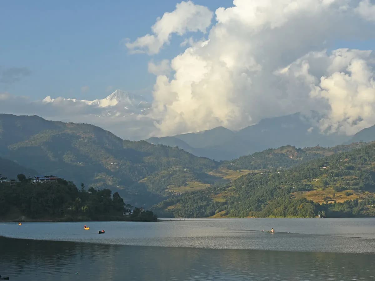 Scenic view of Begnas Lake in Pokhara with the Annapurna mountain range visible behind green hills