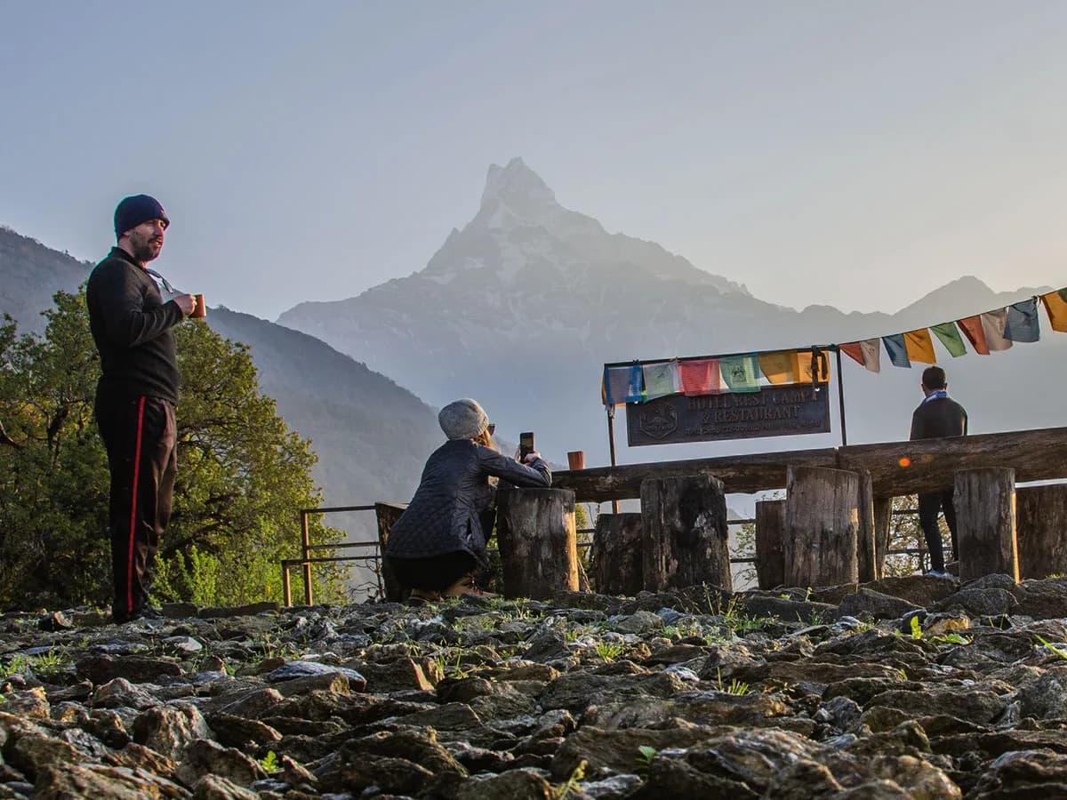 Trekkers drinking tea at Rest Camp enjoying the sunrise view of Machhapuchhre during the Mardi Himal Trek.