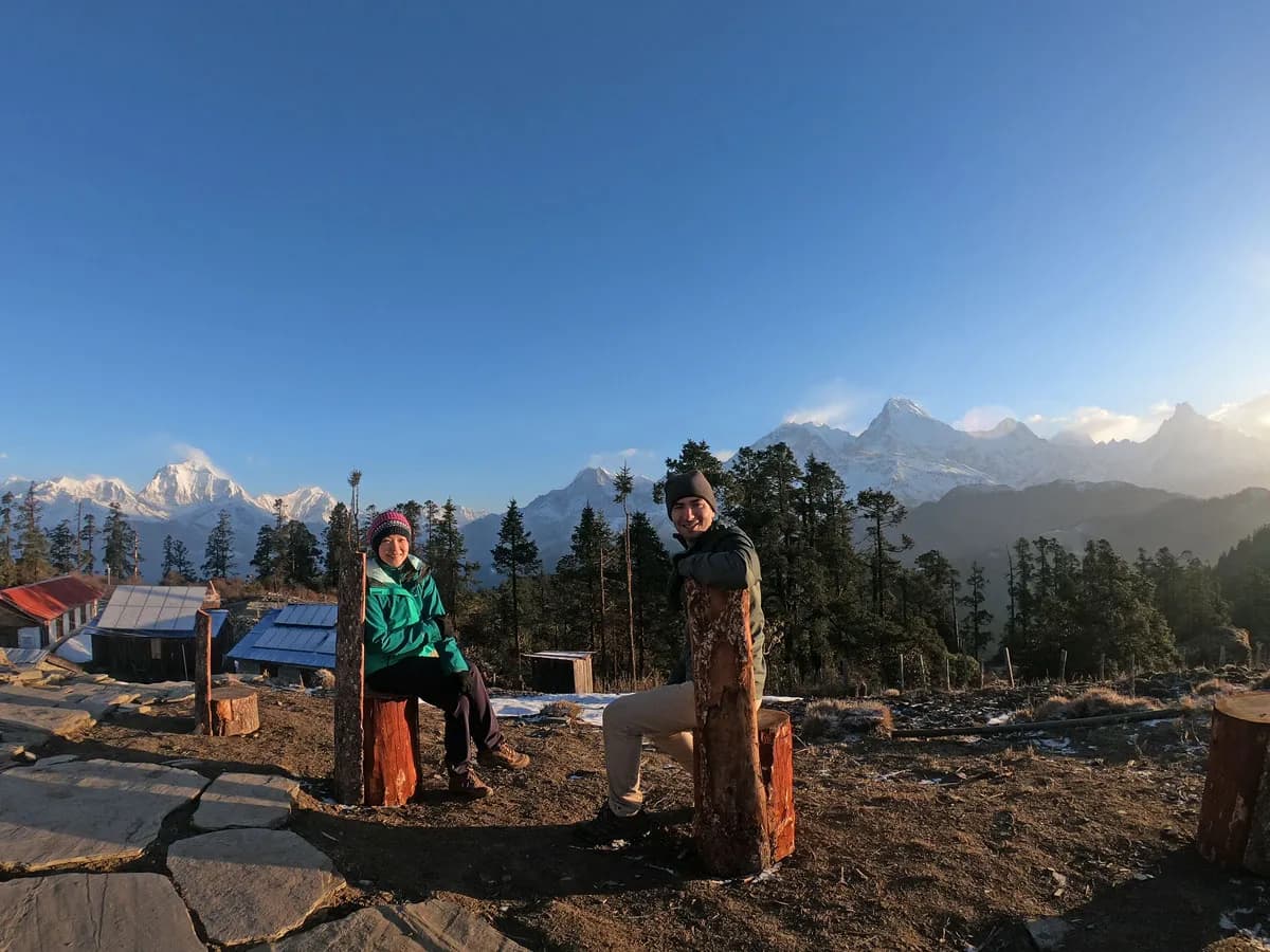 Three happy trekkers the morning view in front of snow-covered mountains.