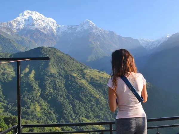 Trekker admiring the scenic view of snow-covered Himalayan peaks on the Annapurna Panorama Trek in Nepal