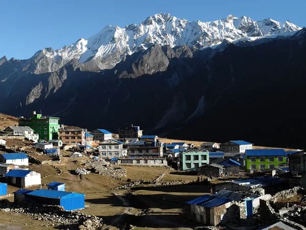 Teahouses and stone buildings of Kyanjin Gompa village nestled beneath dramatic snow-capped peaks on the Langtang Gosaikunda Helambu Trek in Nepal.