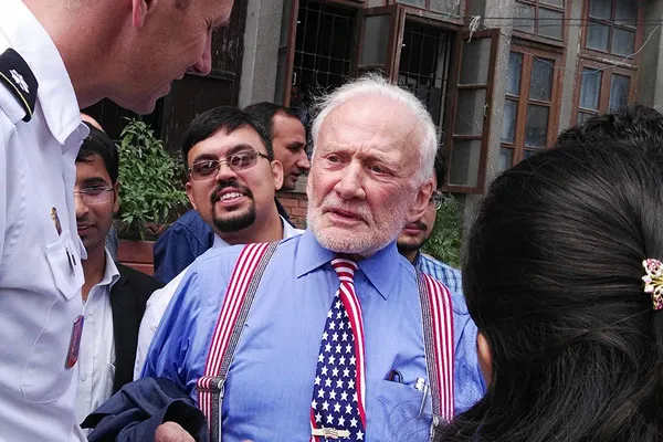 Apollo 11 astronaut Buzz Aldrin wearing an American flag tie and suspenders surrounded by people in Nepal.