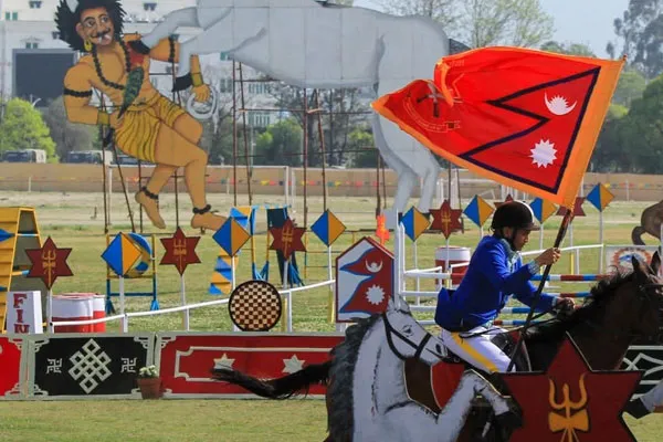 A horse rider carrying the national flag of Nepal while performing maneuvers during the Ghode Jatra horse racing festival at Tundikhel ground.