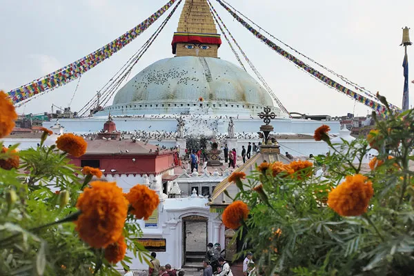 Boudhanath Stupa in Kathmandu surrounded by marigold flowers and prayer flags, representing cultural things to do in Nepal other than trekking.