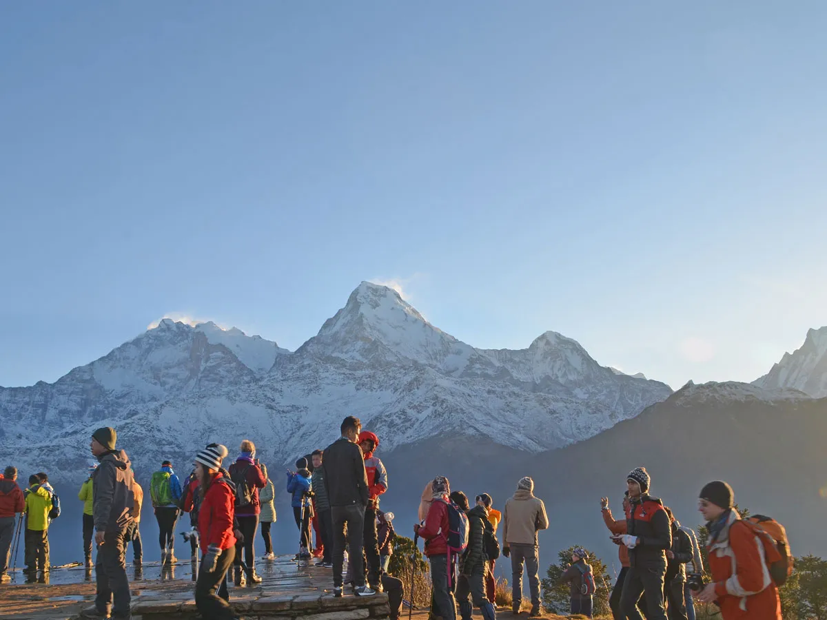 Group of trekkers enjoying sunrise views of the Annapurna mountain range at Poon Hill viewpoint