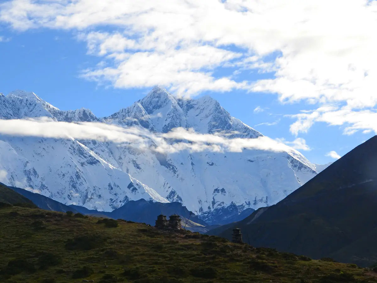 Panoramic view of majestic snow-covered Himalayan mountain peaks under a clear blue sky.