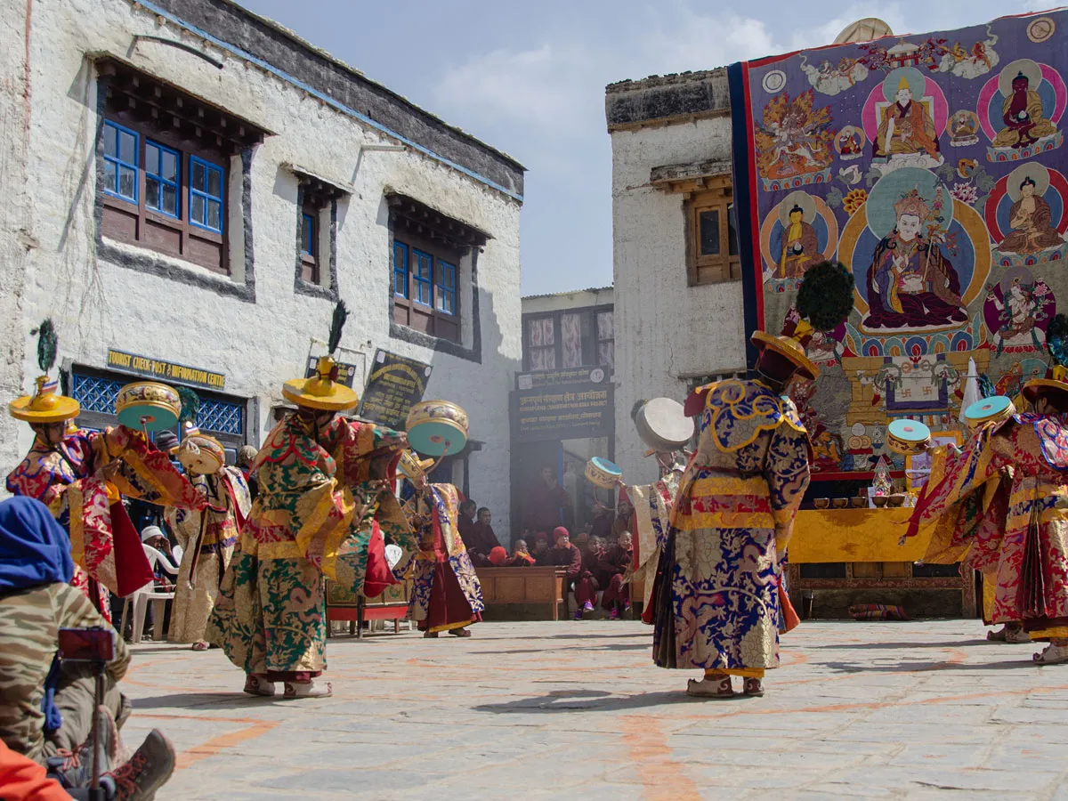 Monks in traditional robes and wide-brimmed hats performing a ritual dance during the Tiji Festival in Lo Manthang.