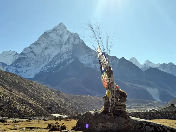 Majestic view of Ama Dablam peak behind traditional prayer flags in the Everest region