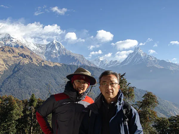 Happy trekkers posing in front of the Himalayan mountain range during the Ghorepani Mardi Himal trek.