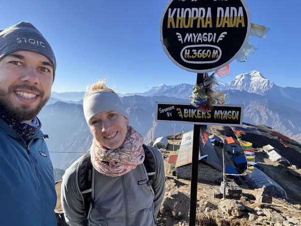 Couple taking a selfie next to the Khopra Dada signpost