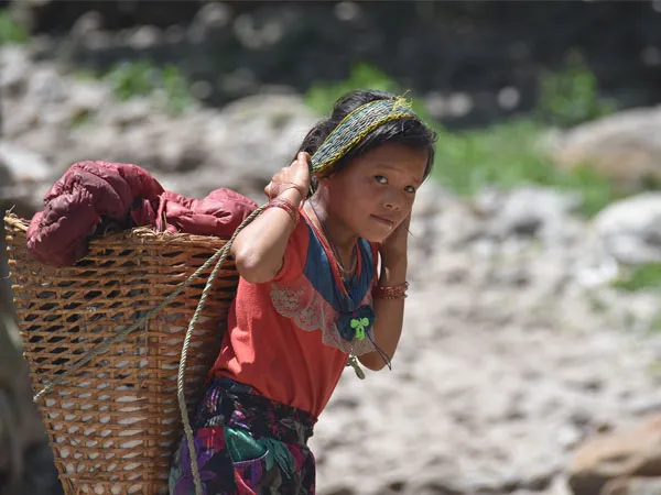 Young local girl carrying a woven bamboo basket on her back during the Lower Manaslu Eco Trek