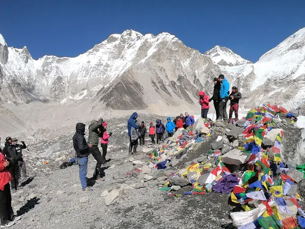 Hikers at prayer-flag decorated Everest Base Camp