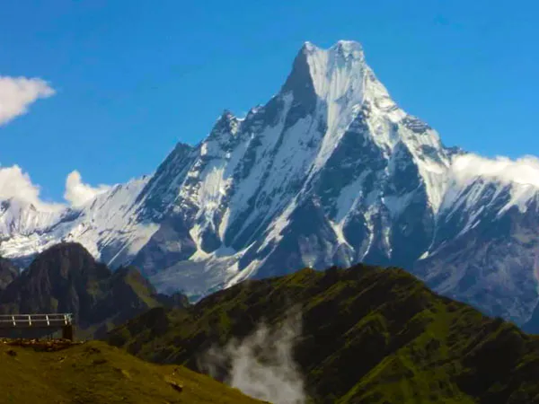 Snow-capped Machhapuchhre (Fishtail) peak standing dramatically above green mountain ridges as seen from the Mulde Viewpoint during the Hidden Lake Dobato Trek in the Annapurna region.