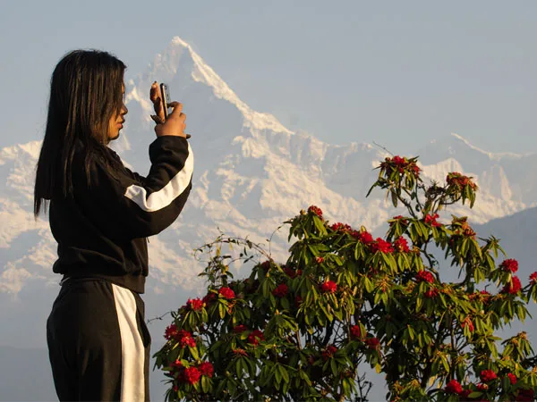 female trekker taking picture at viewpoint