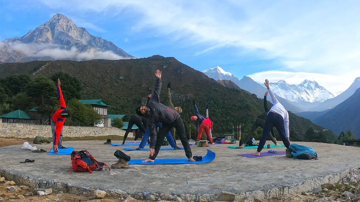 trekkers doing morning yoga at namche helipad with the everest view