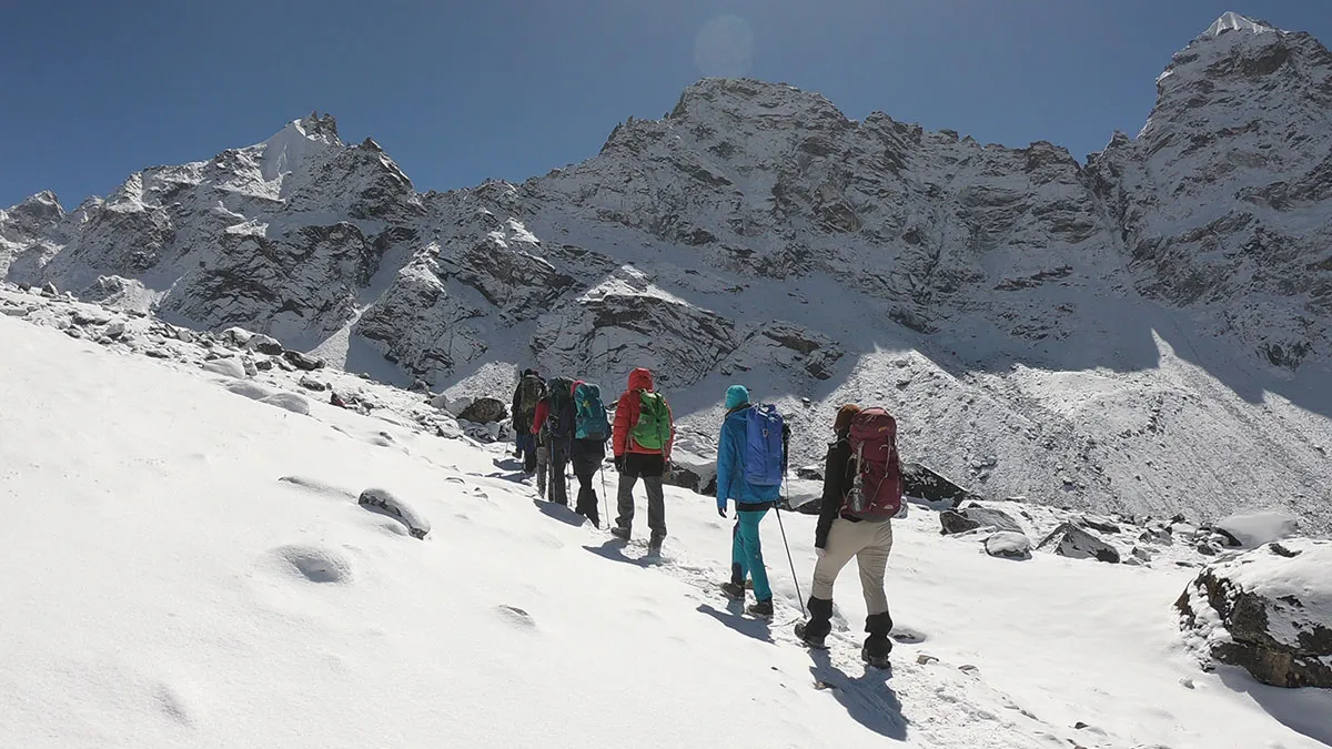 trekkers walking on snowy trail at cho la pass on everest 3 pass trek